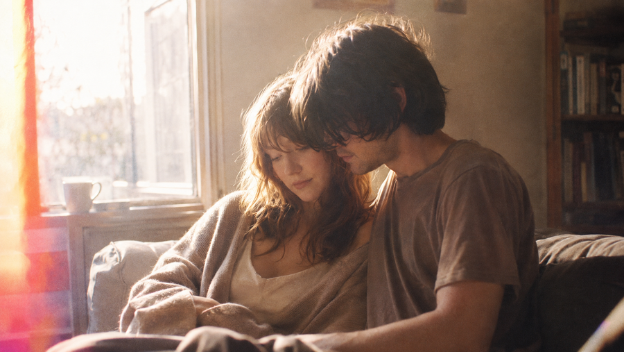 dustlight — standing close in a fogged, sun-flared window frame, prism flare down the left edge. Dust in a shaft of light — the mood of Weightless Everything.